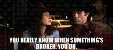 A still from Urban Cowboy: Bud (John Travolta) in a black cowboy hat and Sissy (Debra Winger) sit together in a truck at night, with caption text reading 'You really know when something's broken. You do.'