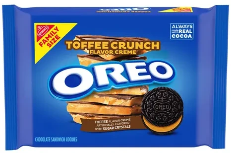 A blue Family Size OREO package with a 'Toffee Crunch' flavor creme banner, a layered toffee graphic, a single chocolate sandwich cookie, and text reading toffee flavor creme artificially flavored with sugar crystals.